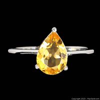 Close-up of the top view of the sterling silver ring with pear-shaped yellow citrine gemstone showing the gem's facets and prong setting.