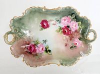 Front view of the hand painted Bavarian dish showing floral rose design with green and pink background, gold edge and two handles.
