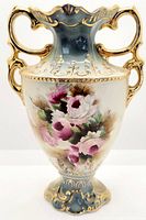 Full front view of the double handled floral urn shaped vase showing pink and green rose decoration with gold accents.