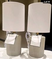 Pair of new Threshold ceramic table lamps with white drum shades and brass necks shown side-by-side.