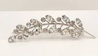 Front view of the brooch showing the clear rhinestones set in a silver-tone leaf branch design.
