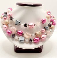 Full view of the triple strand necklace on a display bust showing the color and style of the beads and overall design.