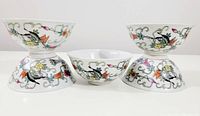 Four vintage porcelain rice bowls with floral designs shown arranged with two bowls upright and two bowls upside down to show full pattern on exterior.