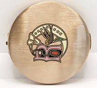 Photo showing the full front of the vintage Stratton compact with the colorful bird and floral enamel design on brass-tone metal.