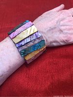 Wide multicolor stretch bracelet on wrist showcasing the curved pieces and color variation