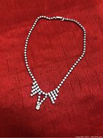 Front view of a 14-inch silver-tone necklace featuring stones along full length and a central stone cluster.