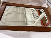 Full view of the 24-inch mirror showing wooden frame and reflective surface.