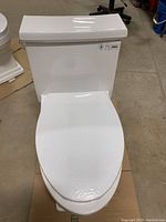 Front view of toilet with closed lid, showing tank decals including cUPC and ADA compliance