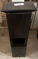 Front and side view of small espresso wooden linen tower with paneled design and open lower shelf.