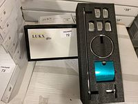 Photo of box with 4-piece bathroom accessory set including towel bar, towel ring, toilet paper holder, and robe hook in foam insert