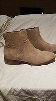 Side view of the beige women's ankle boots showing elastic panel and low stacked heel.