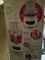 Photo of the food processor box showing model info: extra 4 cup bowl, 12 cup bowl, reversible slicing/shredding disc, chopping/mixing blade, big mouth feed tube.