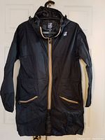 Full view of navy blue K-Way rain coat with front zipper, pockets, hood, and logo patch on chest.