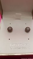 Pair of medium size spherical stud earrings with cubic zirconia stones set in sterling silver inside white jewelry box.
