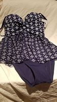 Photo showing one-piece ladies swimsuit in blue with white geometric pattern, size 8 S/M, new and unworn condition