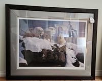 Full view of the framed art print showing wolves on snowy rocks.