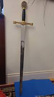 Full-length display sword leaning against wall