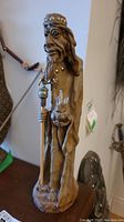 Side view of the leather wizard figurine showing detailed face, beard, crown, and eye design.