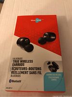 Front of Blue Hive Bluebuds packaging showing black true wireless earbuds and charging case on red and white background with brand logo and Bluetooth symbol.