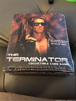 Sealed wax box of The Terminator Collectible Card Game featuring Arnold Schwarzenegger on the front with dark fiery background.