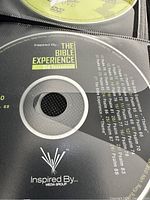 Close-up photo of a CD from 'The Bible Experience' Old Testament set showing track titles and the Inspired By Media Group logo.