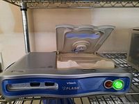 VTech V.Flash console with open disk drive tray and illuminated power button