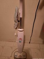 Bissell steam mop full view with microfiber pad and power cord wrapped on handle.