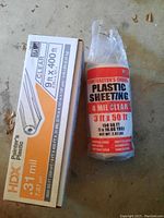 Two rolls of plastic sheeting - one large HDX brand 9 ft x 400 ft roll with .31 mil thickness and one smaller Contractor's Choice 3 ft x 50 ft roll with 4 mil thickness.