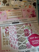 Close-up of multiple scrapbook paper pads from Recollections showing assorted pastel and floral themed designs
