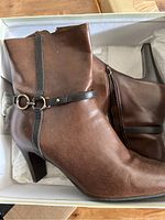 Liz Claiborne brown leather boots showing side view and decorative strap.