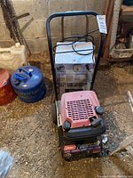 Front view of the generator with red engine cover and the battery charger on the back side, showing the wheels and handle on the generator.
