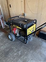 Left-side view showing red engine housing, black frame and pneumatic wheel