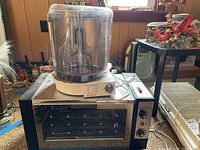 Sunbeam Carousel Rotisserie on top of Toastmaster oven combo unit, showing full setup including dome and oven door.