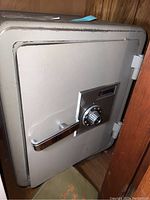 Front view of the Sentry safe showing the combination dial lock, chrome handle, and general wear on the metal surface.