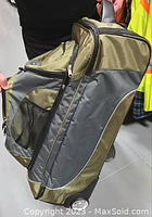 Side view of green and grey Whiteridge luggage showing mesh side pockets and zippered compartments.