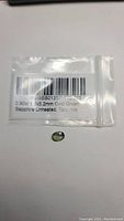 Photo of the natural green sapphire gemstone with label showing 0.90ct, 6x5.2mm, oval shape, untreated from Tanzania