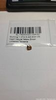 Photo of heart-shaped natural champagne zircon gemstone with packaging label showing details.