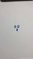 Three oval cut kyanite gemstones on white background, showing size and color.