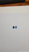 Two oval cut blue Kyanite gemstones in royal blue and cornflower blue on white background.