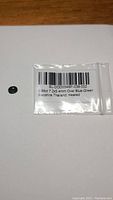 Green sapphire gemstone inside a small plastic bag with label stating 0.98ct 7.2x5.4mm Oval Blue-Green Sapphire Thailand Heated