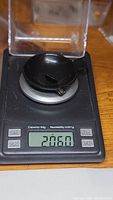 Weighing the tourmaline gemstone on a digital precision scale showing 2.06 carats weight.