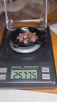 Tourmaline crystals weighed on a digital scale showing 25.77 carats total weight.