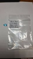 Topaz gemstone in a small resealable plastic bag labeled with carat, cut, origin and dimensions