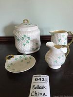 Full set overview showing canister with lid, two pitchers, and small plate decorated with shamrocks.