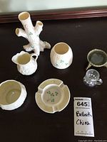 All six items arranged on dark surface showing the complete lot including creamer, sugar bowl, tree trunk vase, ashtray, iris salt bowl, and small glass item.