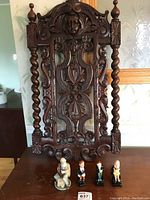Front view of the wood carved panel and four figurines in front