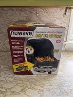 Front of box showing product and key features including temperature control, pre-heat function, cooking recipes, and safe start sensor.