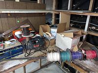 Overall photo showing the Skil jigsaw, several wire spools in different colors, and a cluttered workbench surface with other items.
