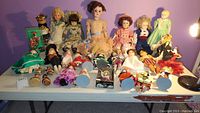Full table view showing row of larger and smaller dolls against purple wall