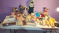 Wide view of entire lot on table showing multiple dolls, tubes and loose parts